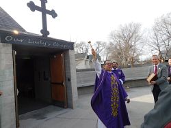 Feligrés con sus manos hace y dona cruz para capilla de parroquia demostrando su devoción 