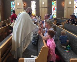 Local Catholics rejoice at once again gathering for Mass, receiving the Eucharist