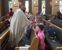 Local Catholics rejoice at once again gathering for Mass, receiving the Eucharist